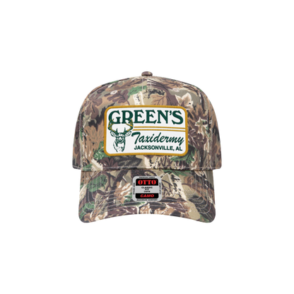 Camouflage cap with Green's Taxidermy logo on a white background